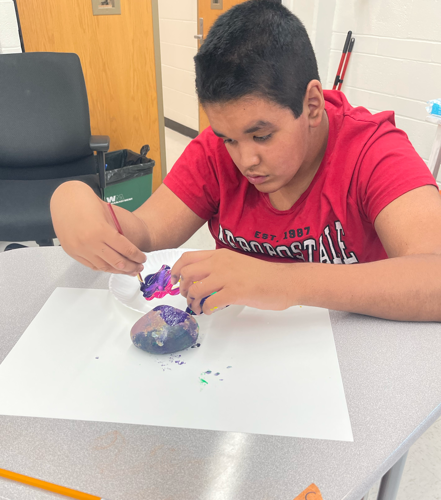 Student painting a rock 
