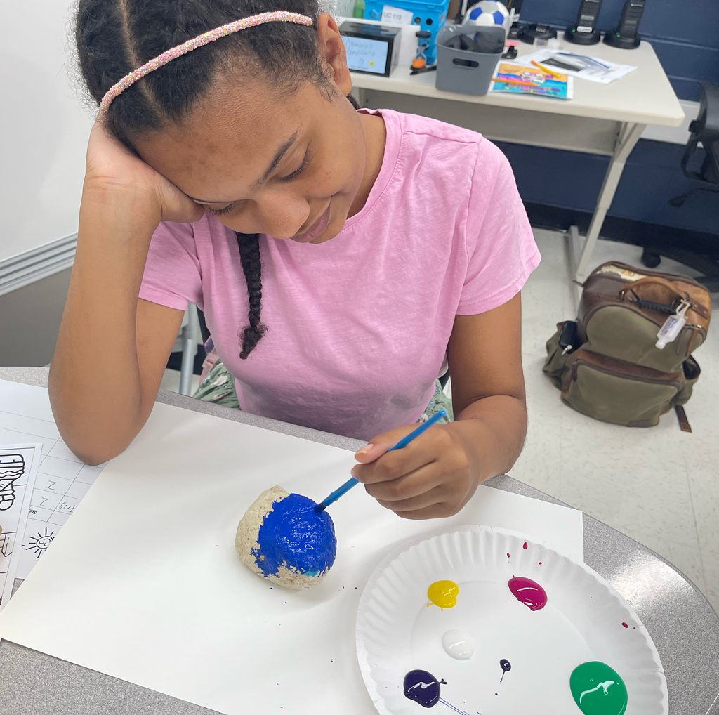Student painting a rock 