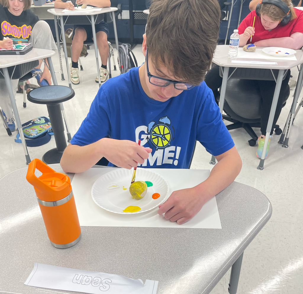 Student painting a rock 
