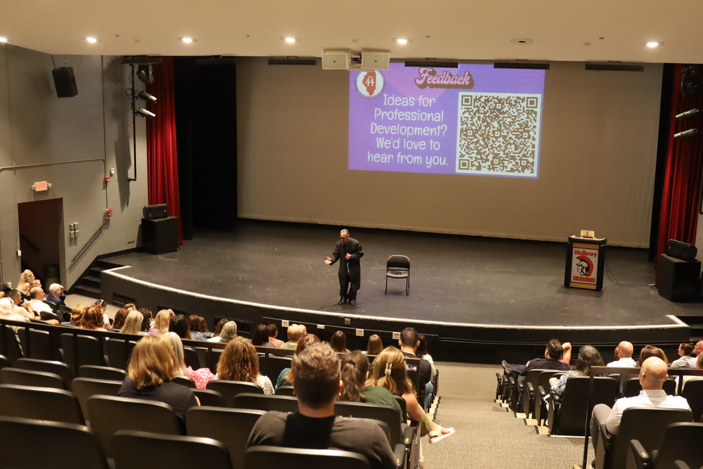 A speaker in front of an audience in the auditorium