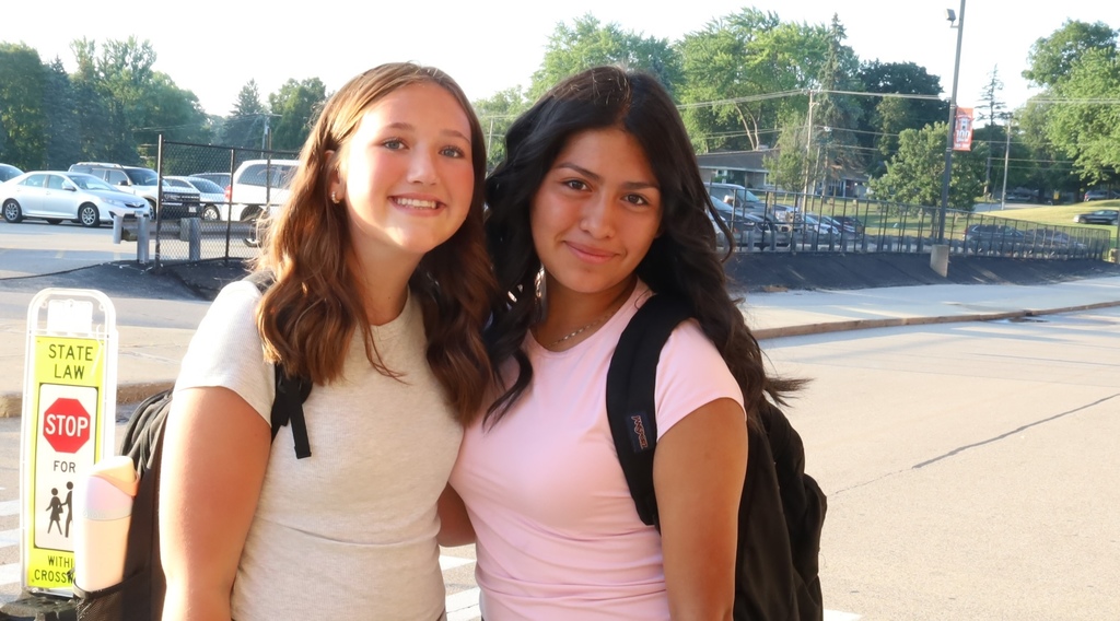 Two students smiling outside of school