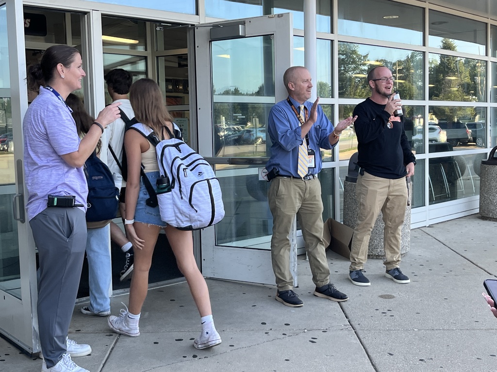 Staff at doors, students walking in 