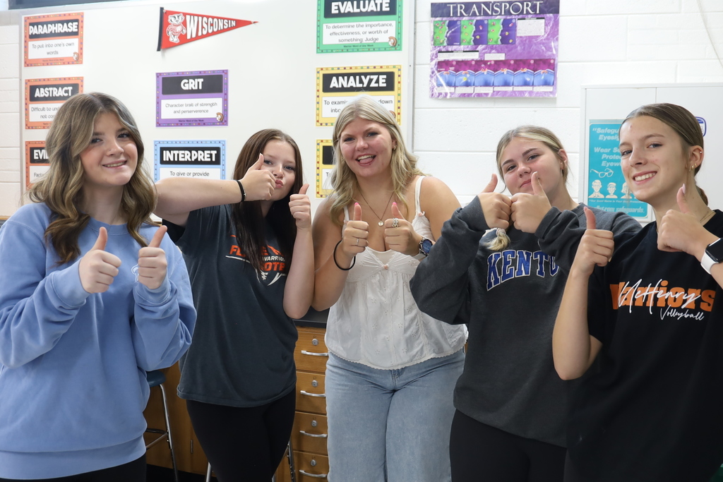 Five students holding thumbs up 