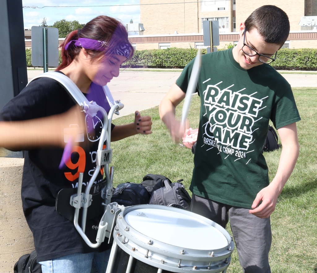 Two students playing a marching band  drum