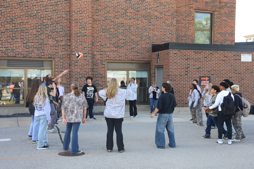 Students ina circle throwing a volleyball