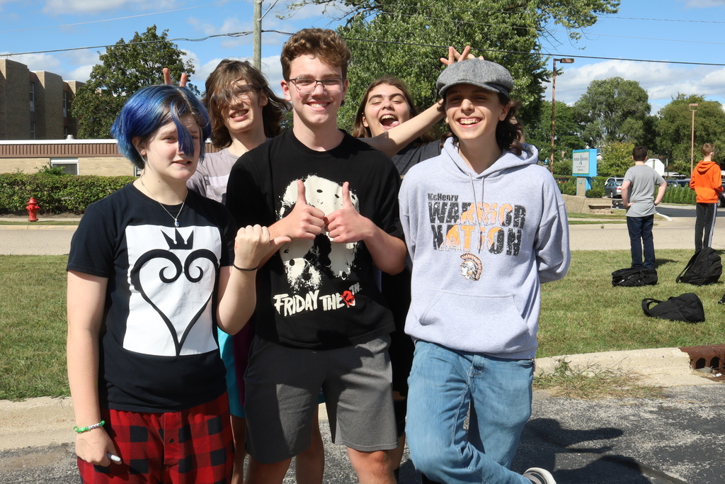 Five students posing some of them doin bunny ears on each other, one doing thumbs up