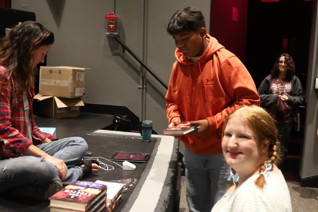 Mindy McGinnis with her books and two sutdents