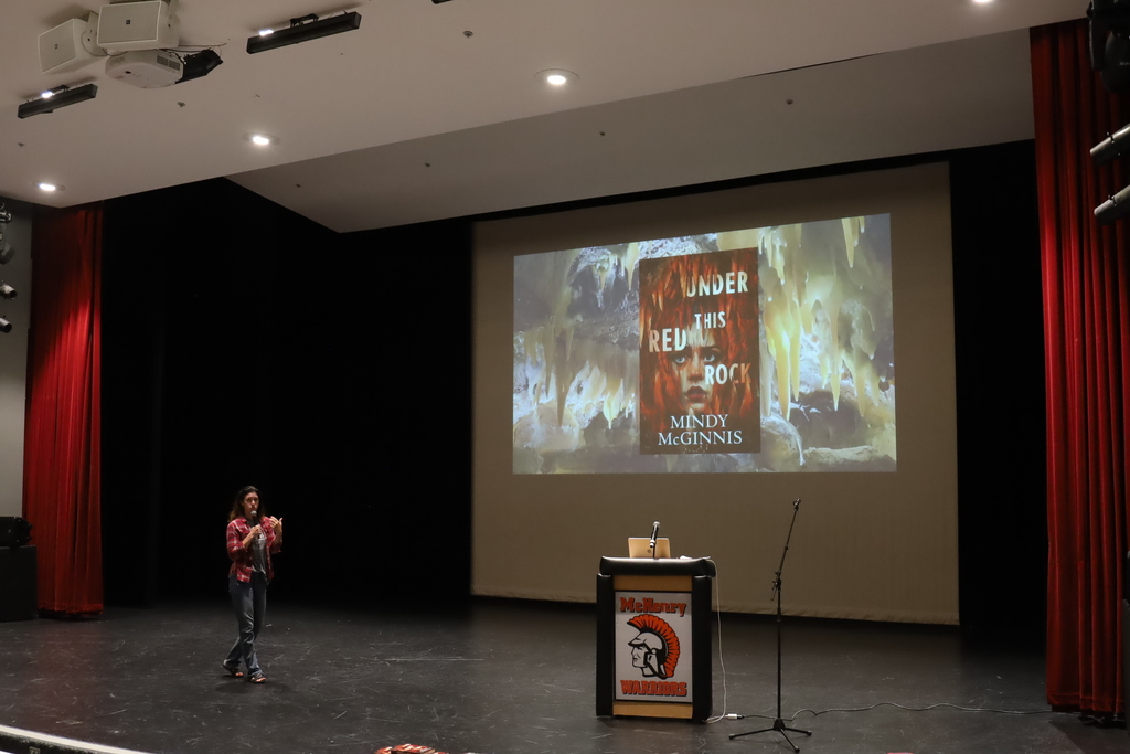 Mindy McGinnis in front of a slide of her book Under the Red Rock