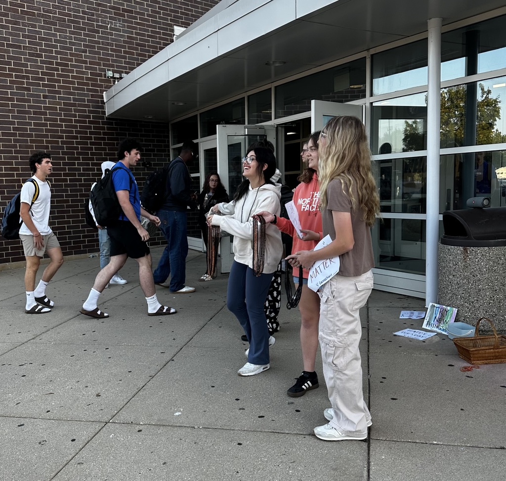 Students at the entrance holding beads 