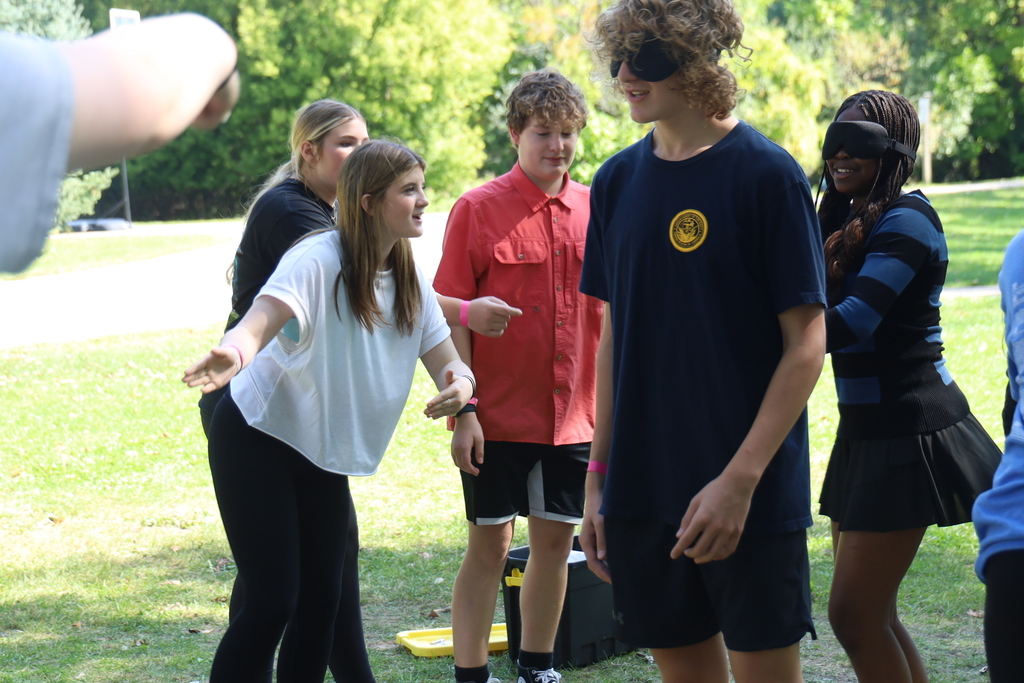 A student pointing to two students blindfolded