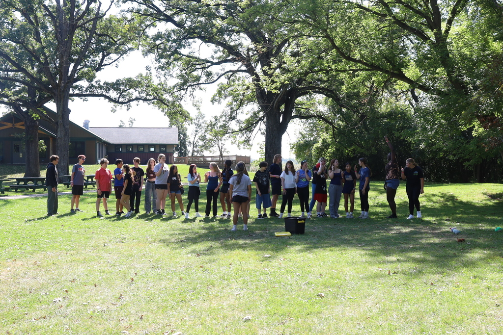 Students standing in a line with a leader in front of them 