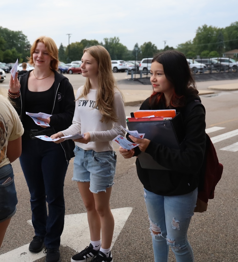Three students handing out flyers