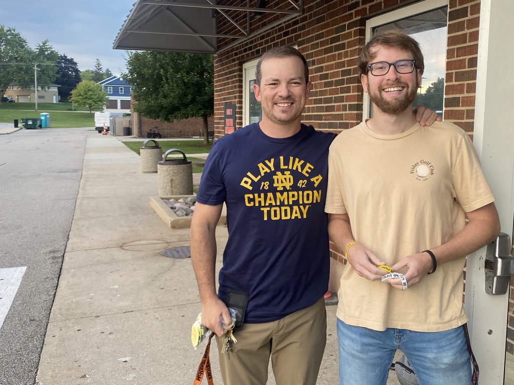 Mr. Sterner and Mr. Stengel at the front of the campus with bracelets