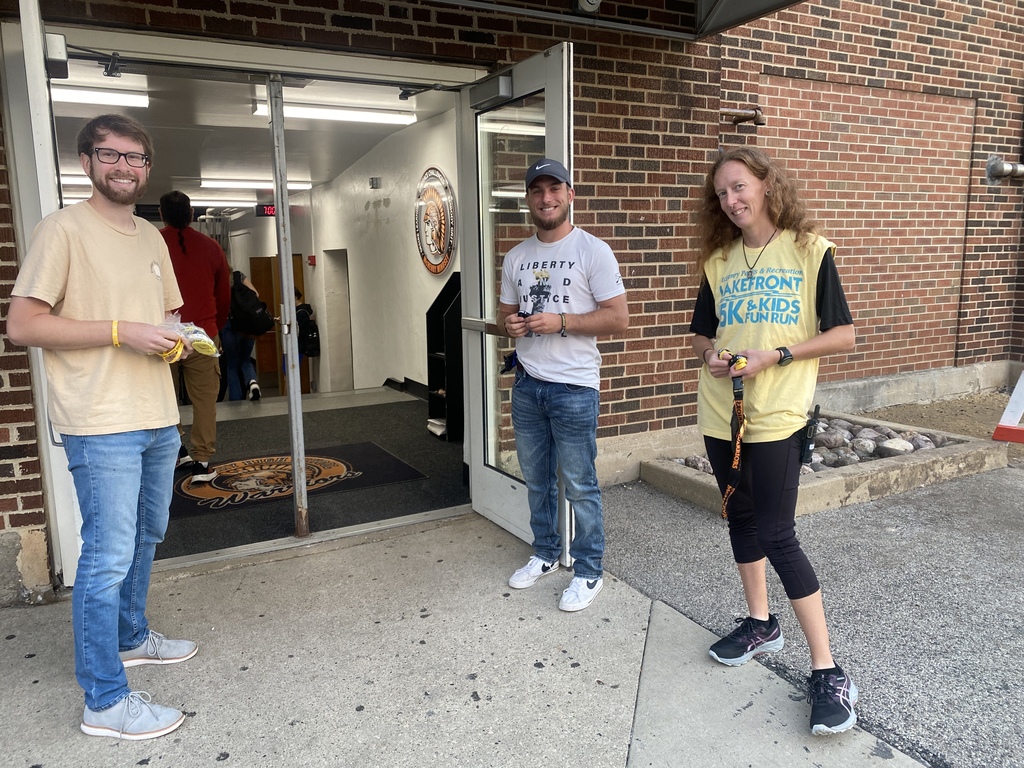 Three staff members standing at the entrance. One holding gold bracelets