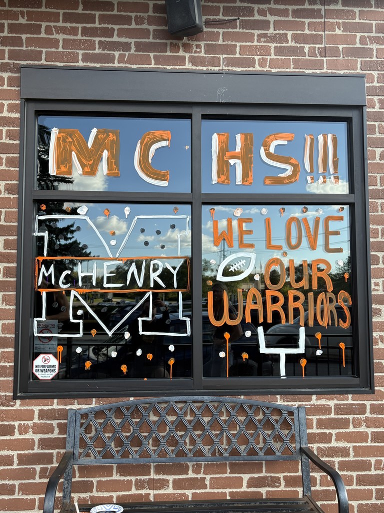 Photos of students painting storefront windows in downtown McHenry to celebrate the start of homecoming with a parade