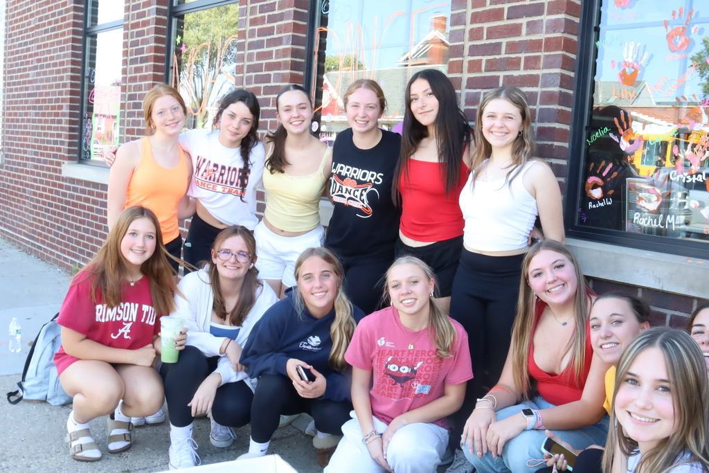 Group of students in front of windows