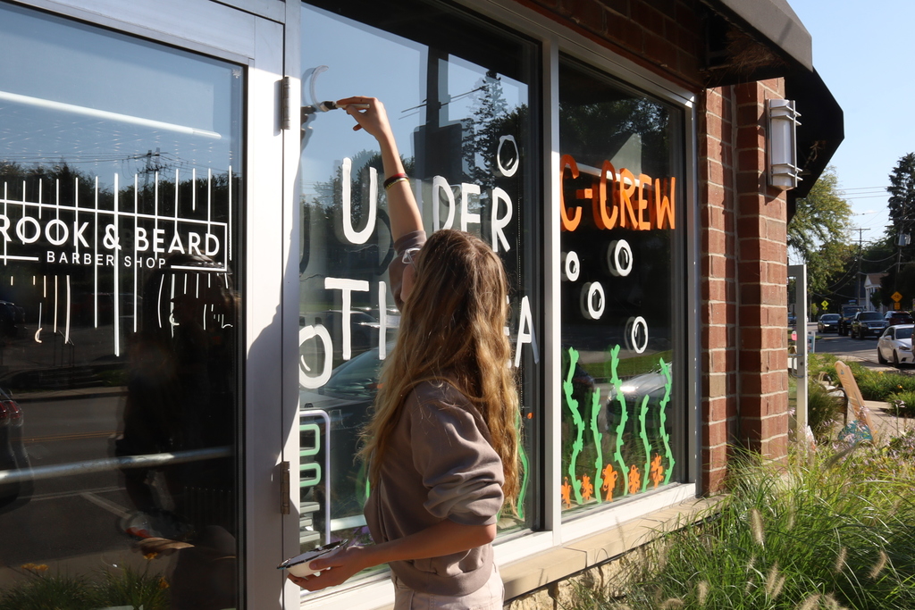 Student painting Under the Sea on the Window