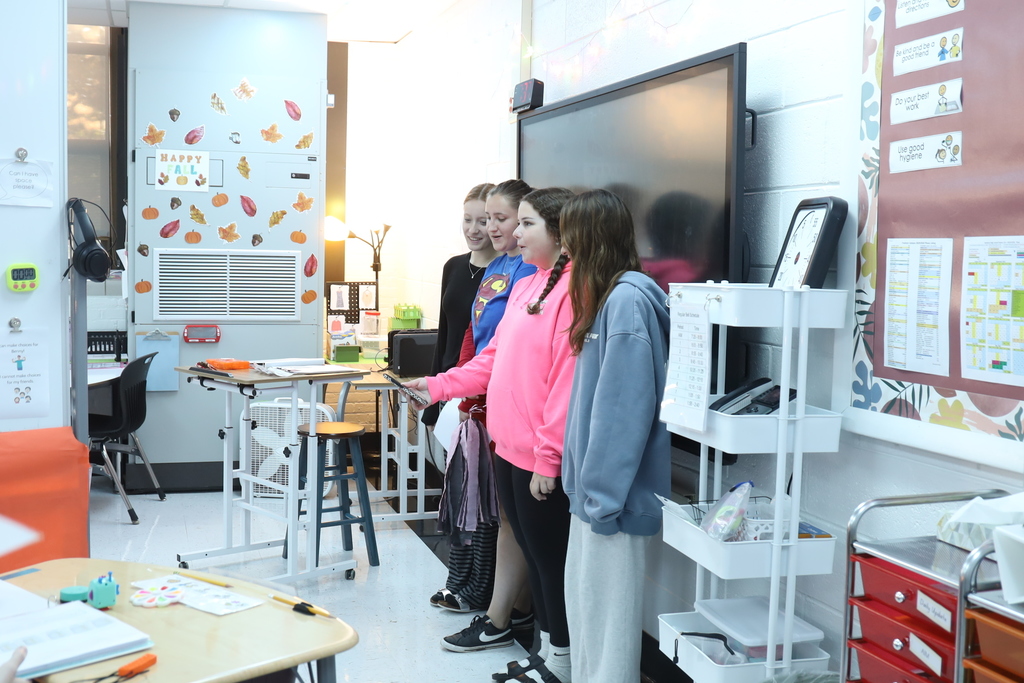 Students singing in front of a class 