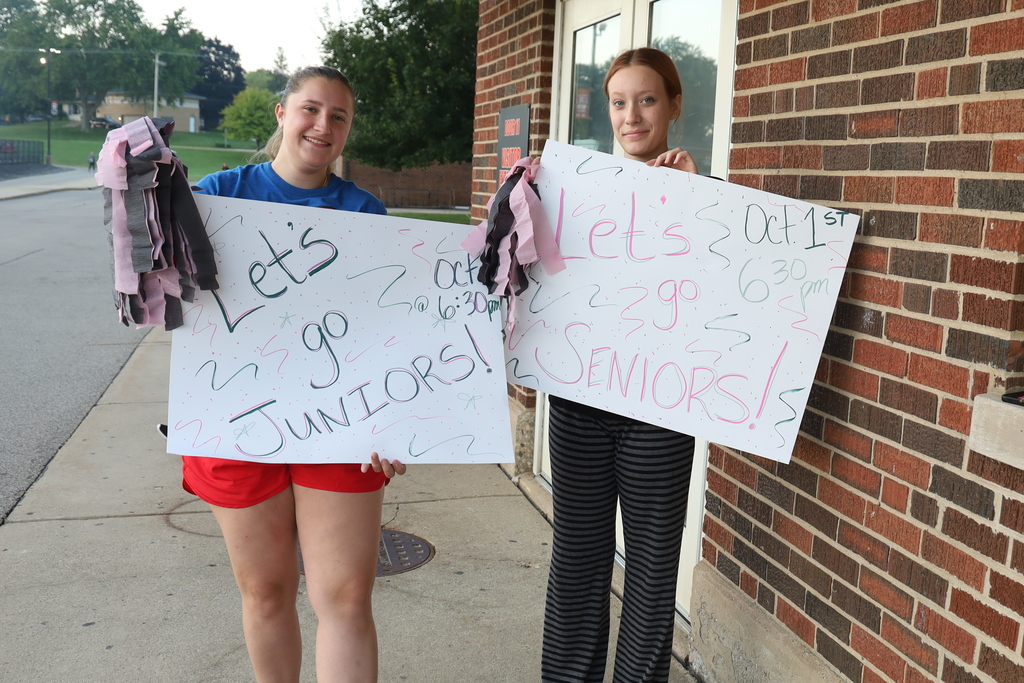 Students holding signs that say Let's go Juniors Let's go Seniors! 