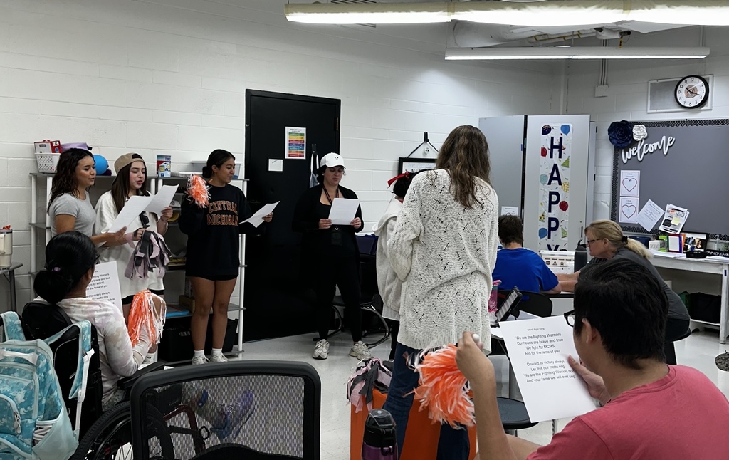 Students singing in front of a class 
