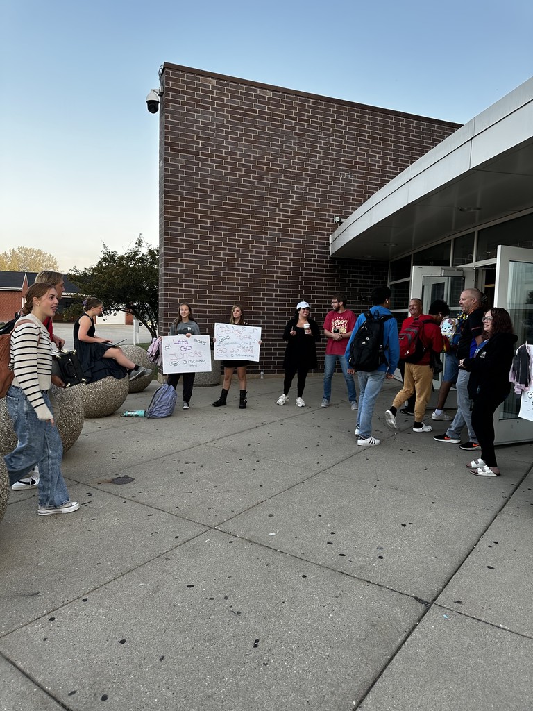 Students walking in with other students holding Powder Puff signs 