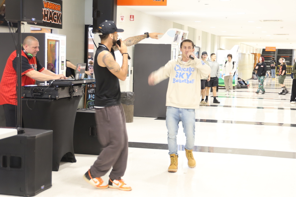 Student singing with DJ booth 
