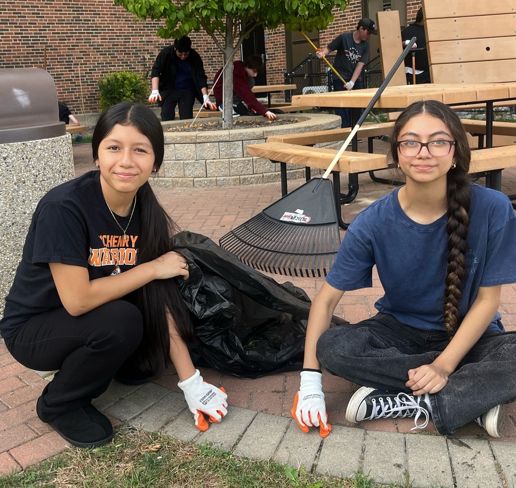 Students with a trash bag and rake 