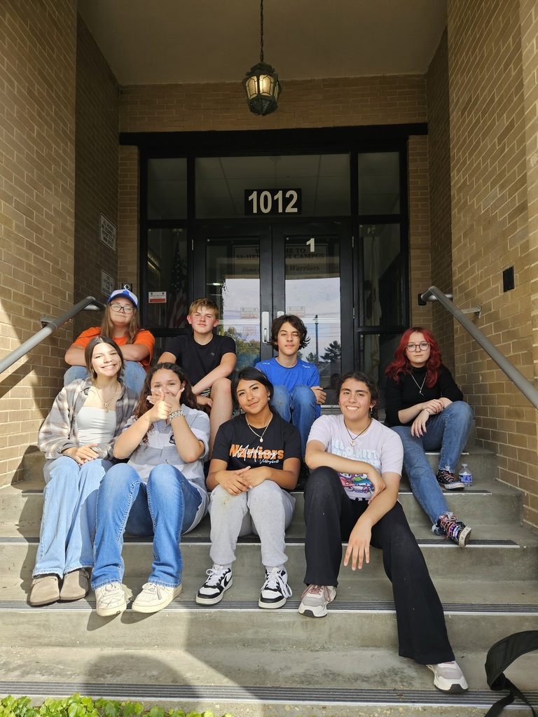 Students sitting in front of the school 
