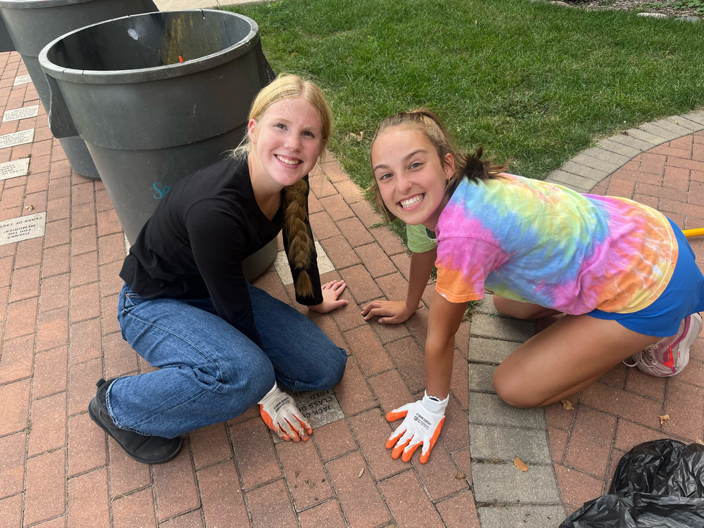Students on the ground cleaning up 