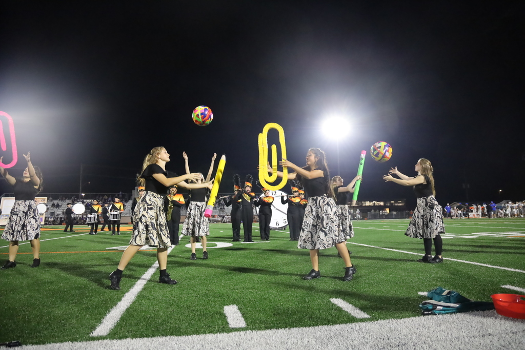 Color guard throwing giant desk supplies in their routine