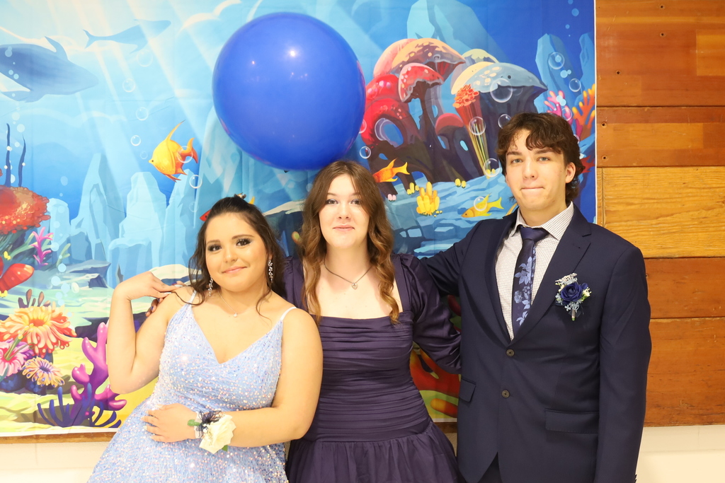 Three students in front of under the sea background