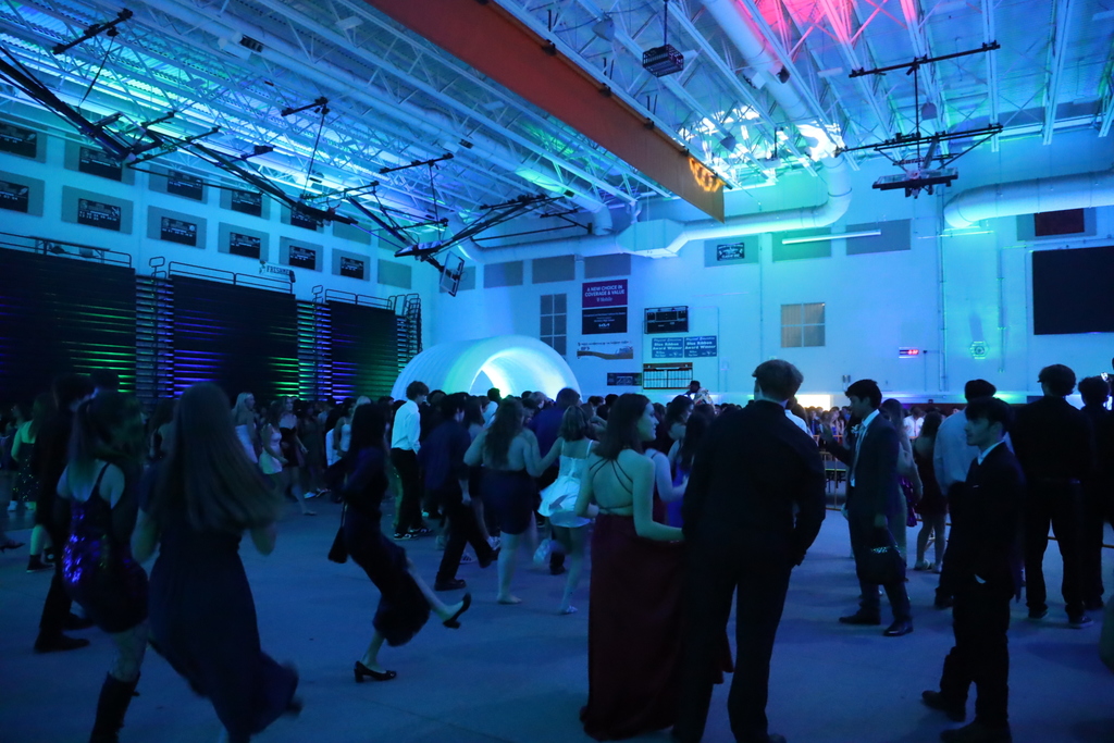 Wide shot of students at the dance in blue lighting 