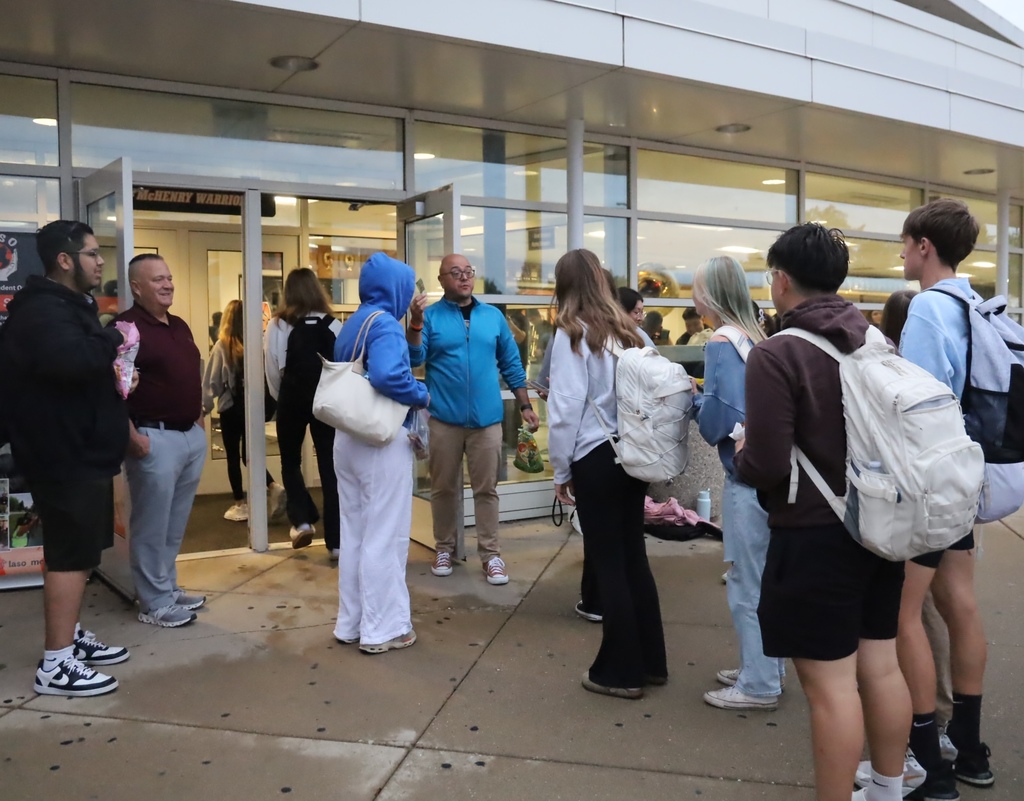Students walking into the school with LASO leader talking to them 