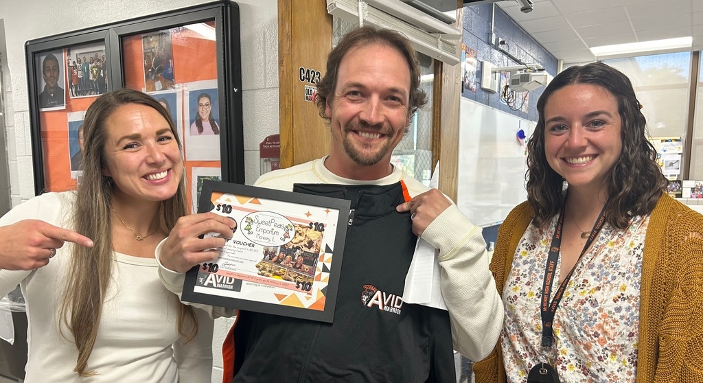 Andre Stegenga holding certificate and jacket. Two people next to him