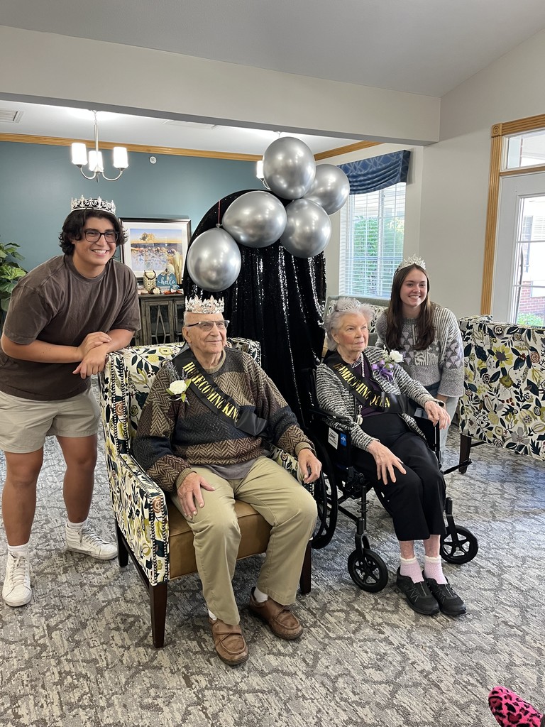 Chase and Kyra with two people at the retirement home wearing sashes and crowns