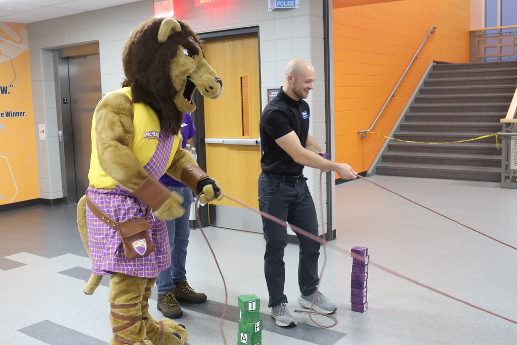 A lion mascot and adult doing a PT exercise
