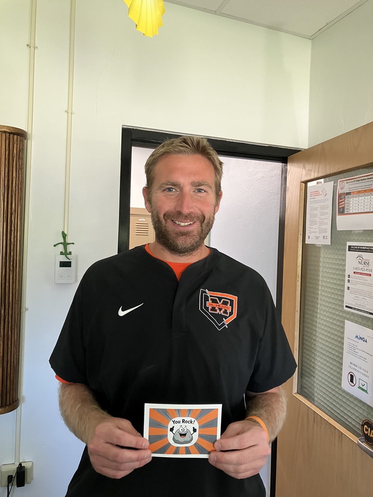 Badgley holding "You rock!" postcard with a rock cartoon