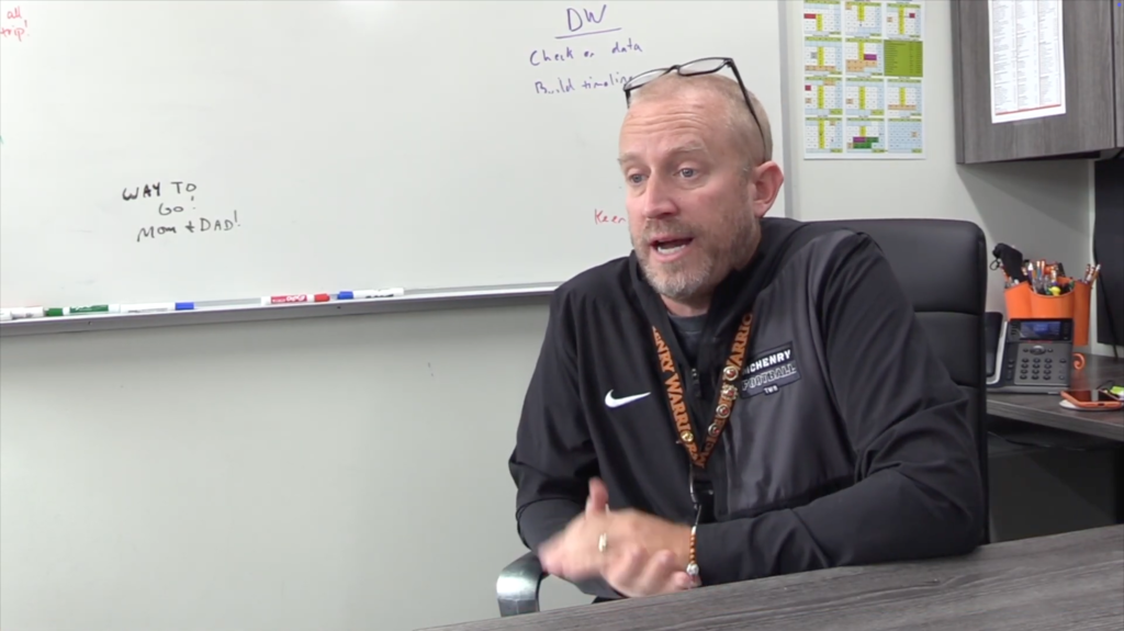 Greg Eiserman talking at his desk