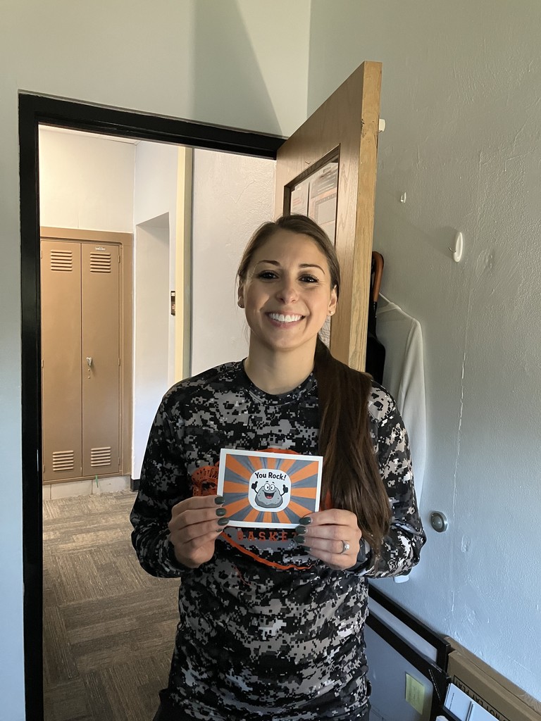 Anna Centella holding a postcard that says "you rock"