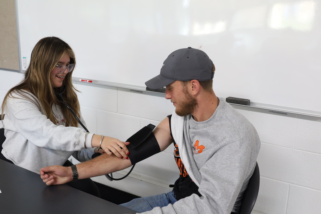 Student check a staff member's blood pressure 