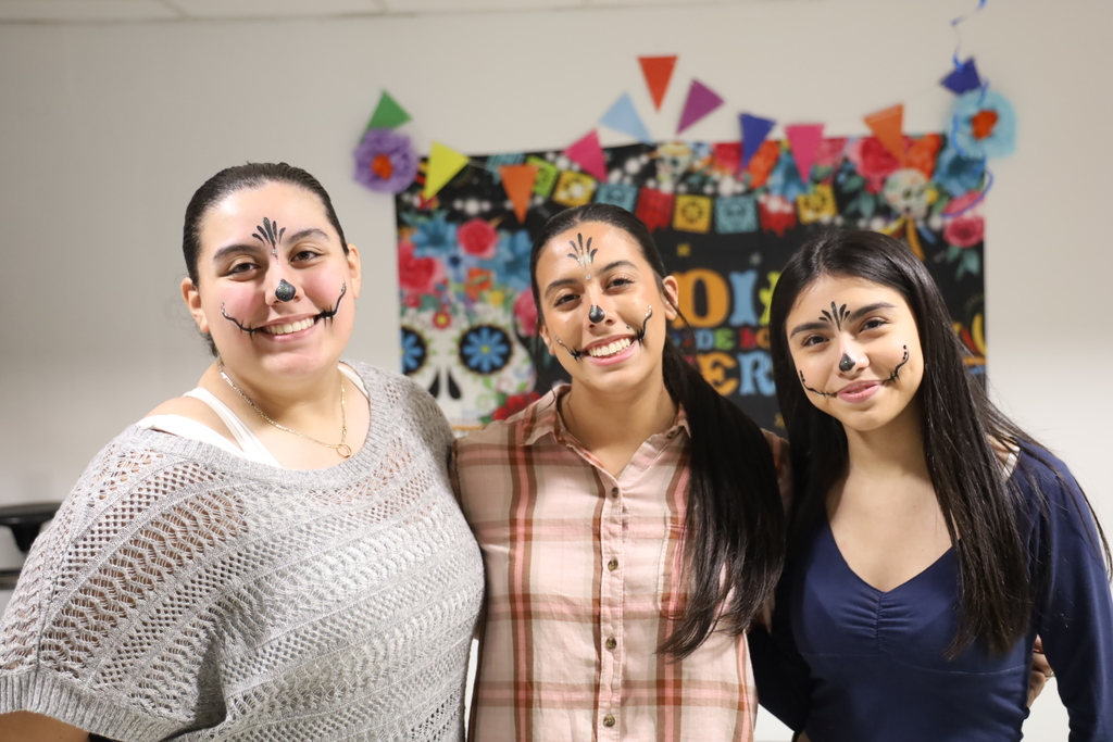 Three students at Day of the Dead event with face paint on them
