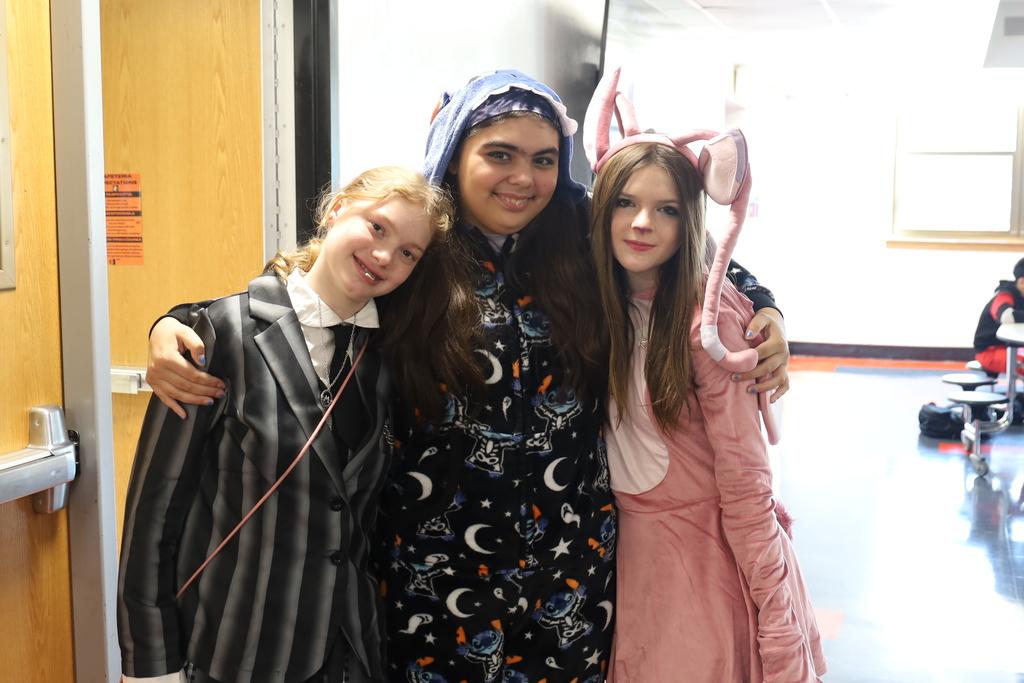 Three students in Halloween costumes, one the pink female alien from Stitch