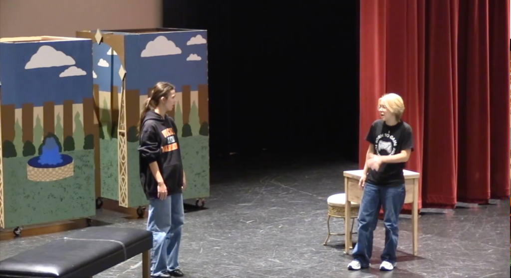 Students practicing on stage for the Upper Campus play