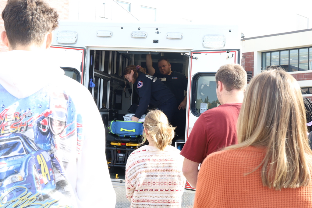 Students looking at the ambulance with the paramedics inside showing equipment