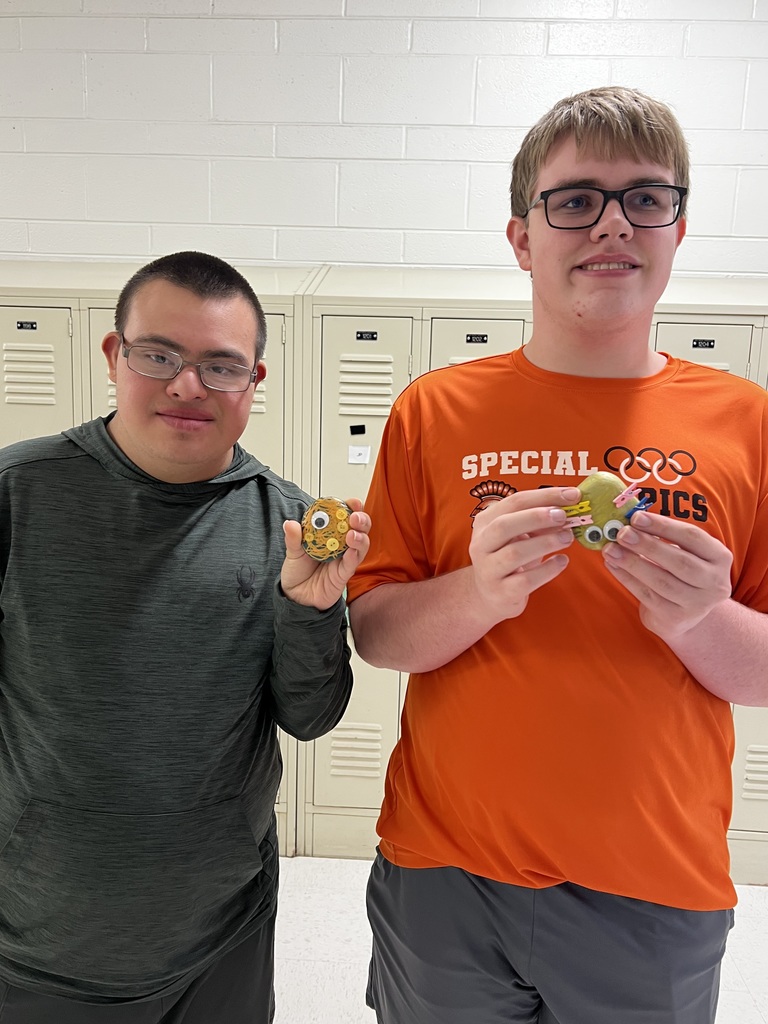 Students holding pet rocks they designed