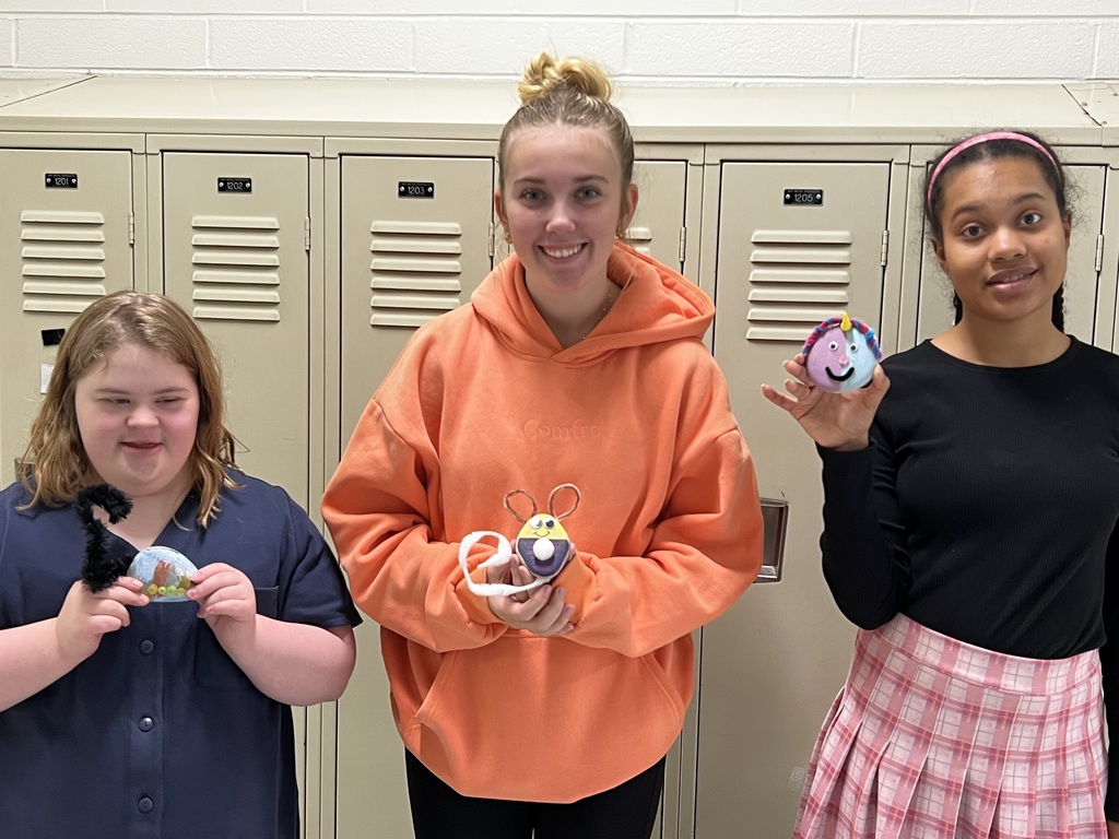 Students holding pet rocks they designed