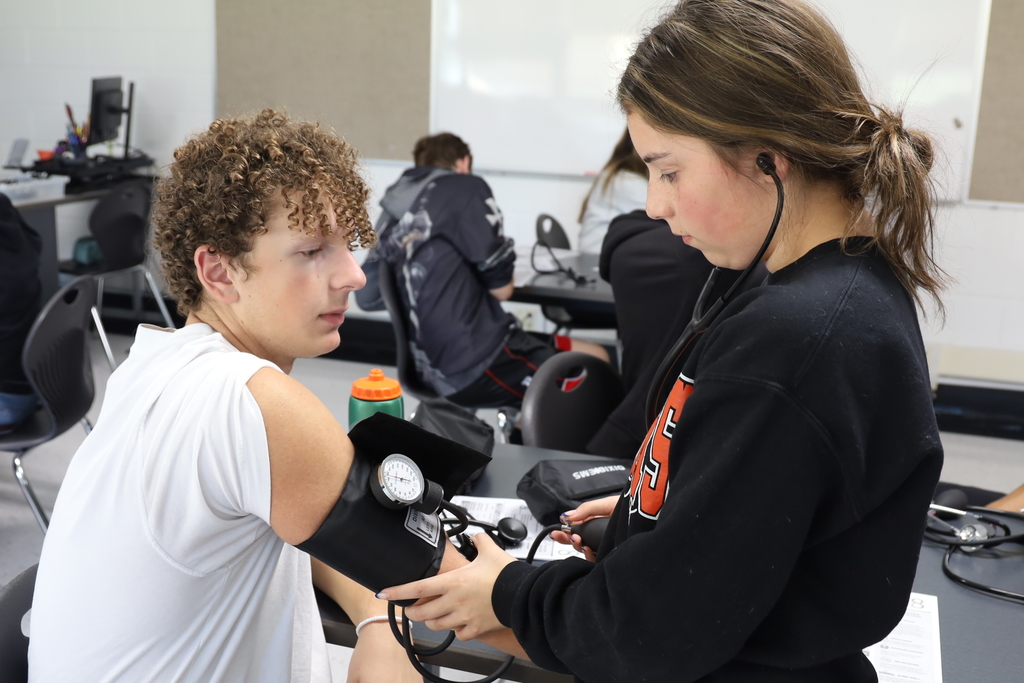 Student taking another student's blood pressure