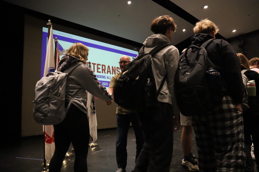 Students shaking hands of veterans