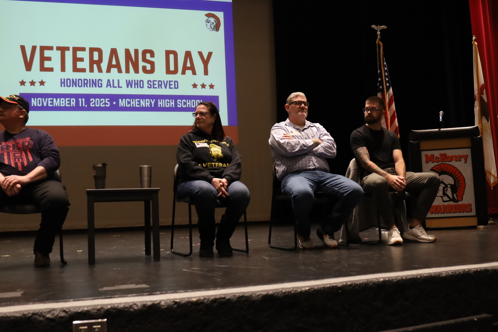 Veterans on stage with Veterans Day background