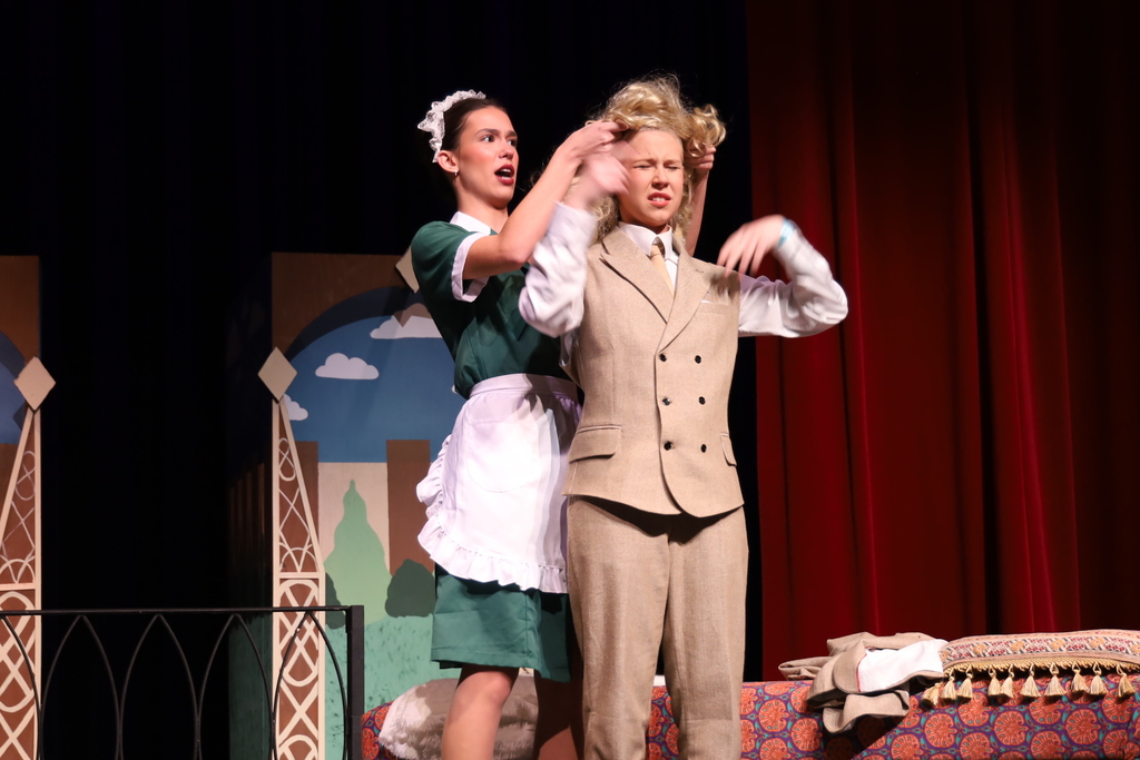 Character putting blonde wig on other chartacter